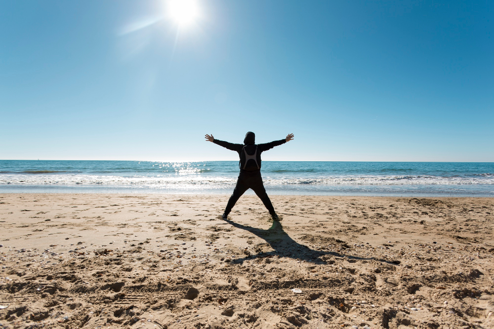 a person standing on a beach with arms outstretched